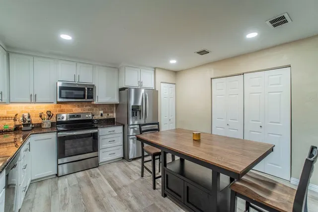 a kitchen with refrigerator cabinets and wooden floor