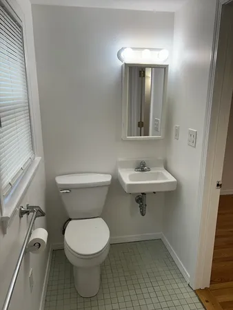 a bathroom with a toilet a sink and mirror
