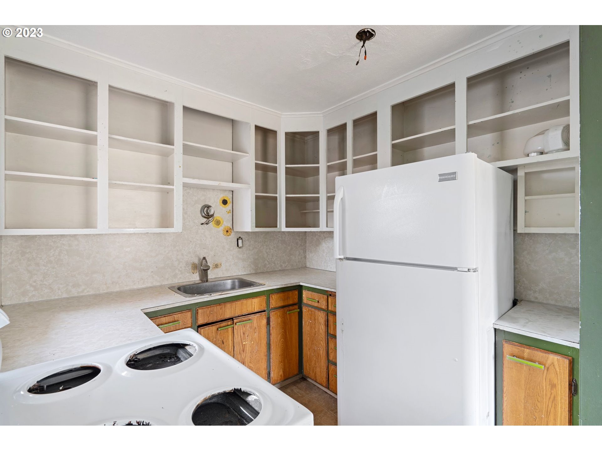 5119 Southeast 68th Avenue Portland, OR 97206 - Photo 12 of 43 a white kitchen with a sink a stove and a refrigerator