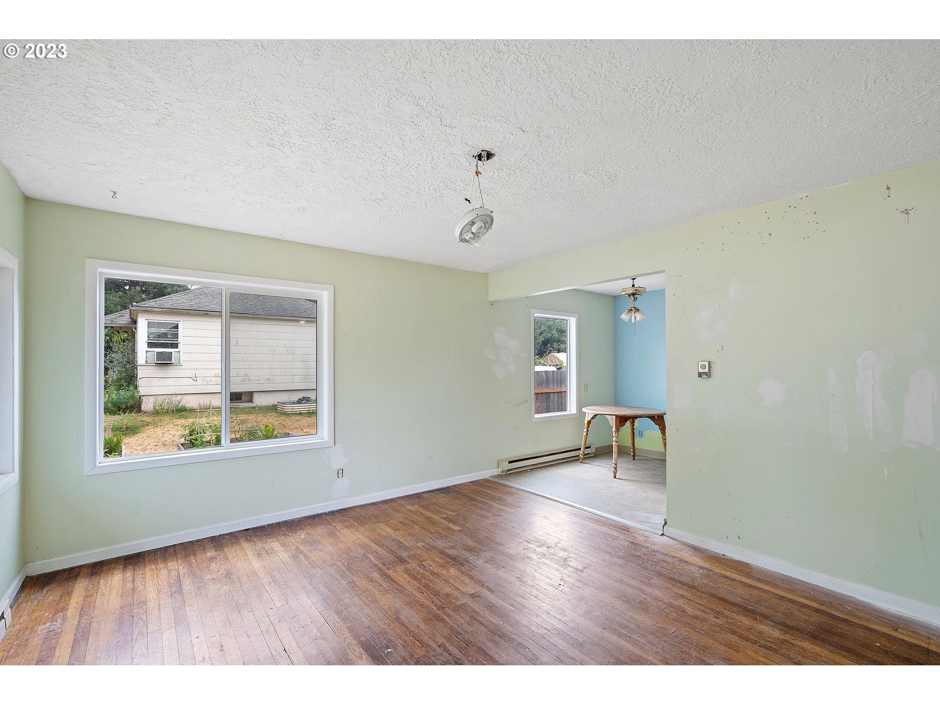 5119 Southeast 68th Avenue Portland, OR 97206 - Photo 5 of 43 a view of an empty room with a window and wooden floor