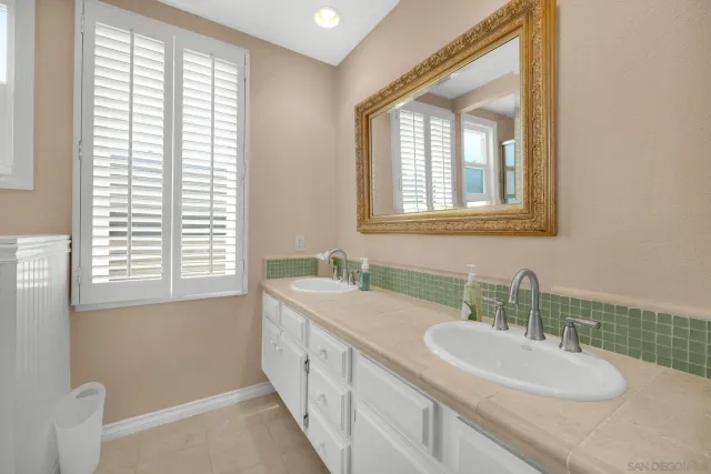 a bathroom with a double vanity sink and a mirror