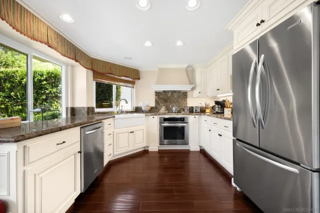 a kitchen with white cabinets and white appliances