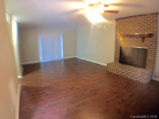 9242 Fairway Ridge Road Charlotte, NC 28277 - Photo 5 of 17 a view of an empty room with wooden floor and a fireplace