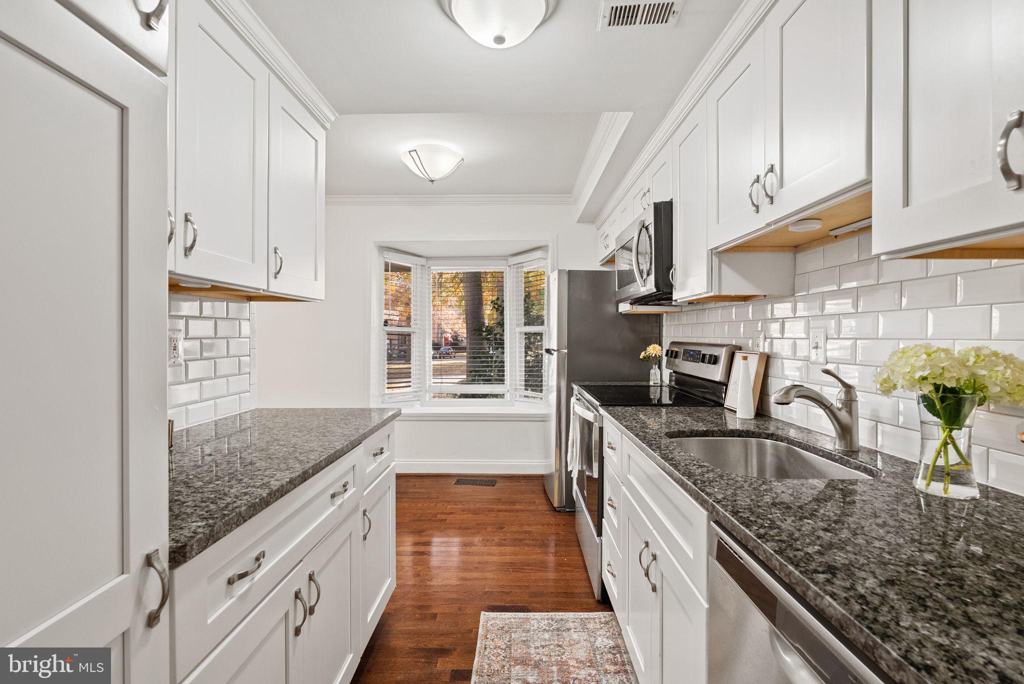 8914 Shamrock Court Springfield, VA 22152 - Photo 11 of 29 a kitchen with stainless steel appliances granite countertop a sink a stove and a wooden cabinets