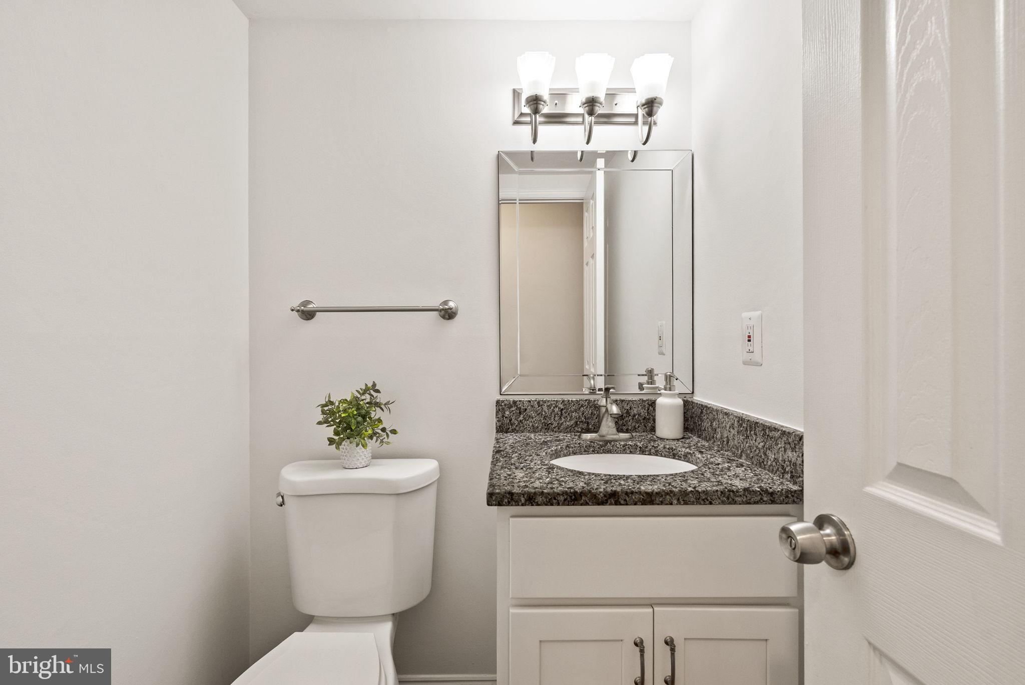 8914 Shamrock Court Springfield, VA 22152 - Photo 15 of 29 a bathroom with a granite countertop sink a toilet and a mirror