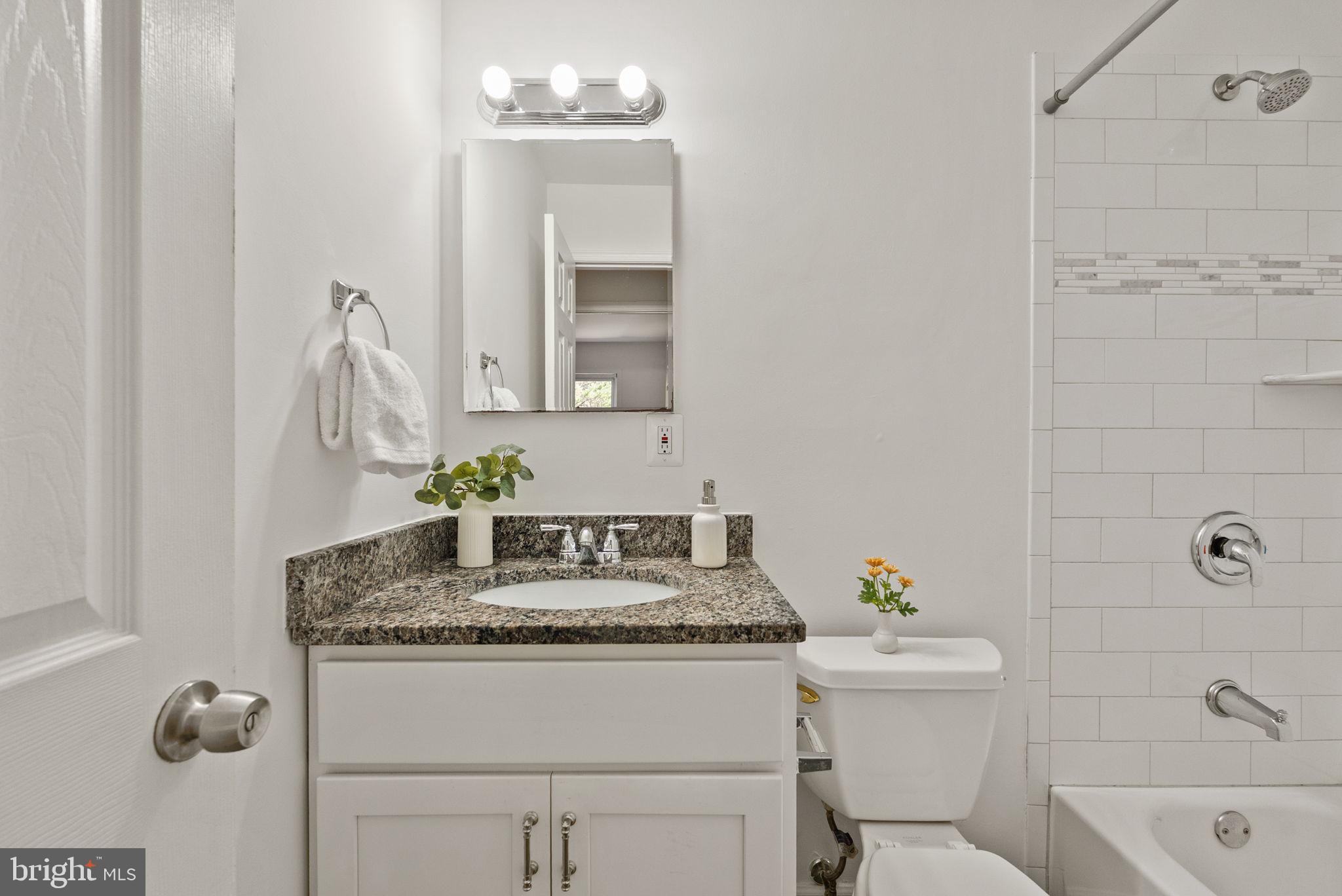 8914 Shamrock Court Springfield, VA 22152 - Photo 18 of 29 a bathroom with a granite countertop sink a toilet and shower