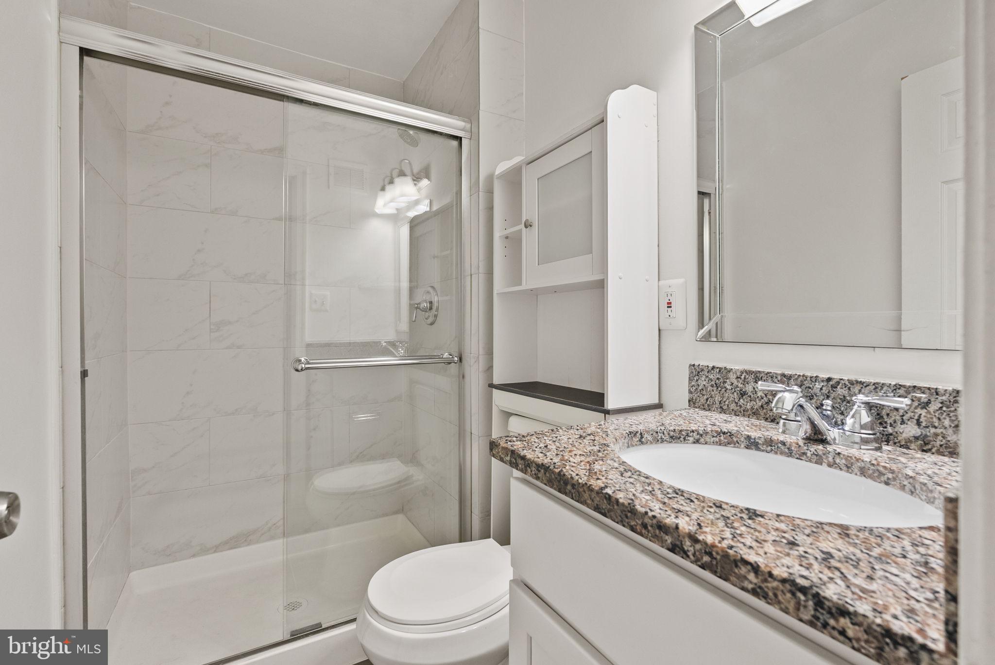 8914 Shamrock Court Springfield, VA 22152 - Photo 24 of 29 a bathroom with a granite countertop sink toilet and shower
