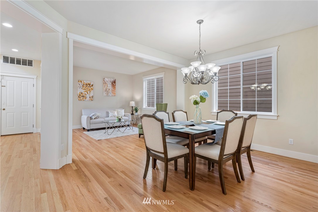 3915 167th Street Southeast Bothell, WA 98012 - Photo 6 of 28 a view of a dining room with furniture a chandelier and wooden floor