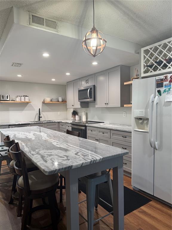 1920 Whitney Way Clearwater, FL 33760 - Photo 11 of 38 a kitchen with stainless steel appliances granite countertop a table chairs sink refrigerator and microwave
