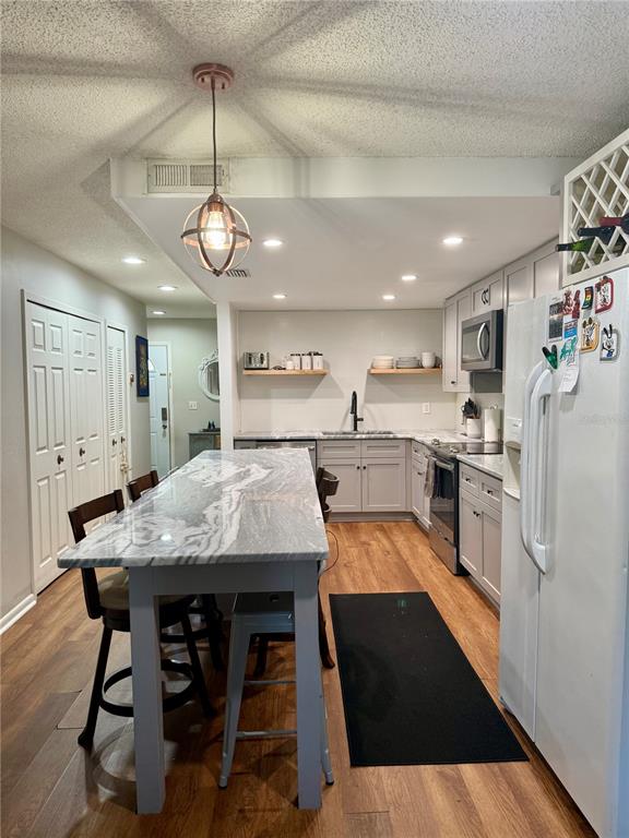 1920 Whitney Way Clearwater, FL 33760 - Photo 2 of 38 a kitchen with stainless steel appliances granite countertop a kitchen island a stove a table and chairs in it