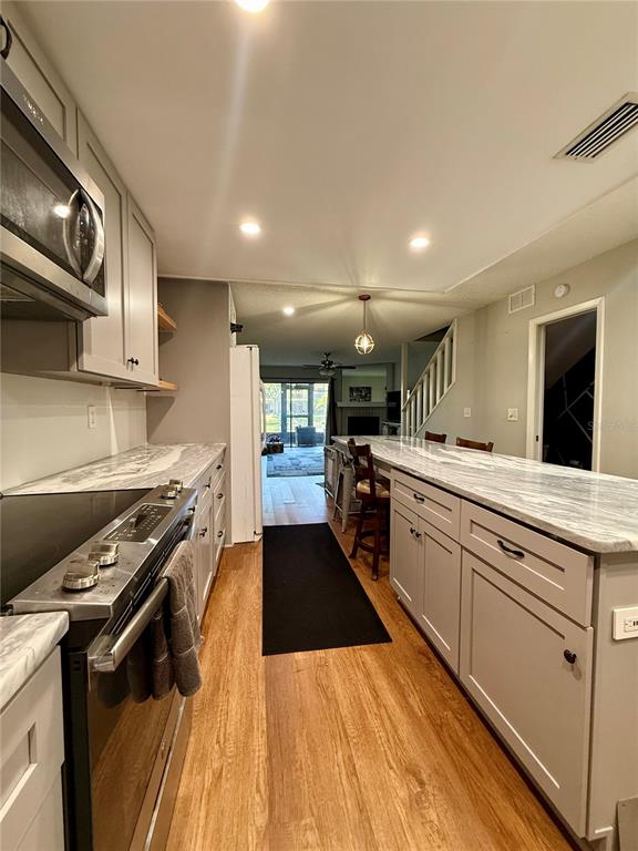 1920 Whitney Way Clearwater, FL 33760 - Photo 10 of 38 a view of a kitchen with kitchen island a stove a sink a refrigerator and chairs