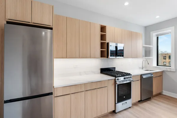 a kitchen with stainless steel appliances a refrigerator sink and stove
