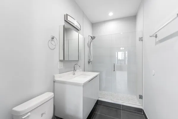 a bathroom with a sink a toilet and shower