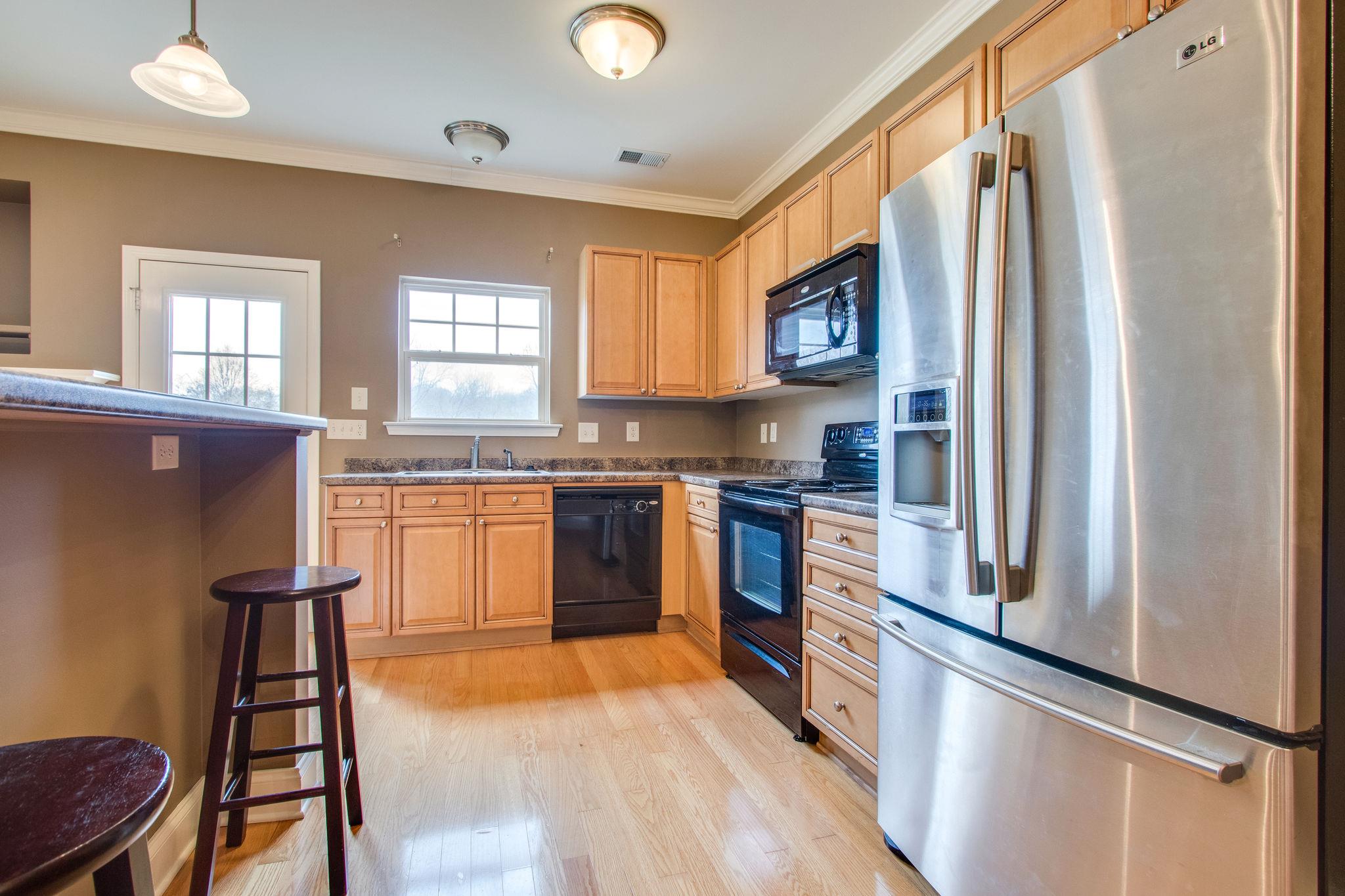 735 Tulip Grove Road, Unit 237 Hermitage, TN 37076 - Photo 12 of 29 a kitchen with stainless steel appliances granite countertop a refrigerator a sink dishwasher a stove and white countertops with wooden floor