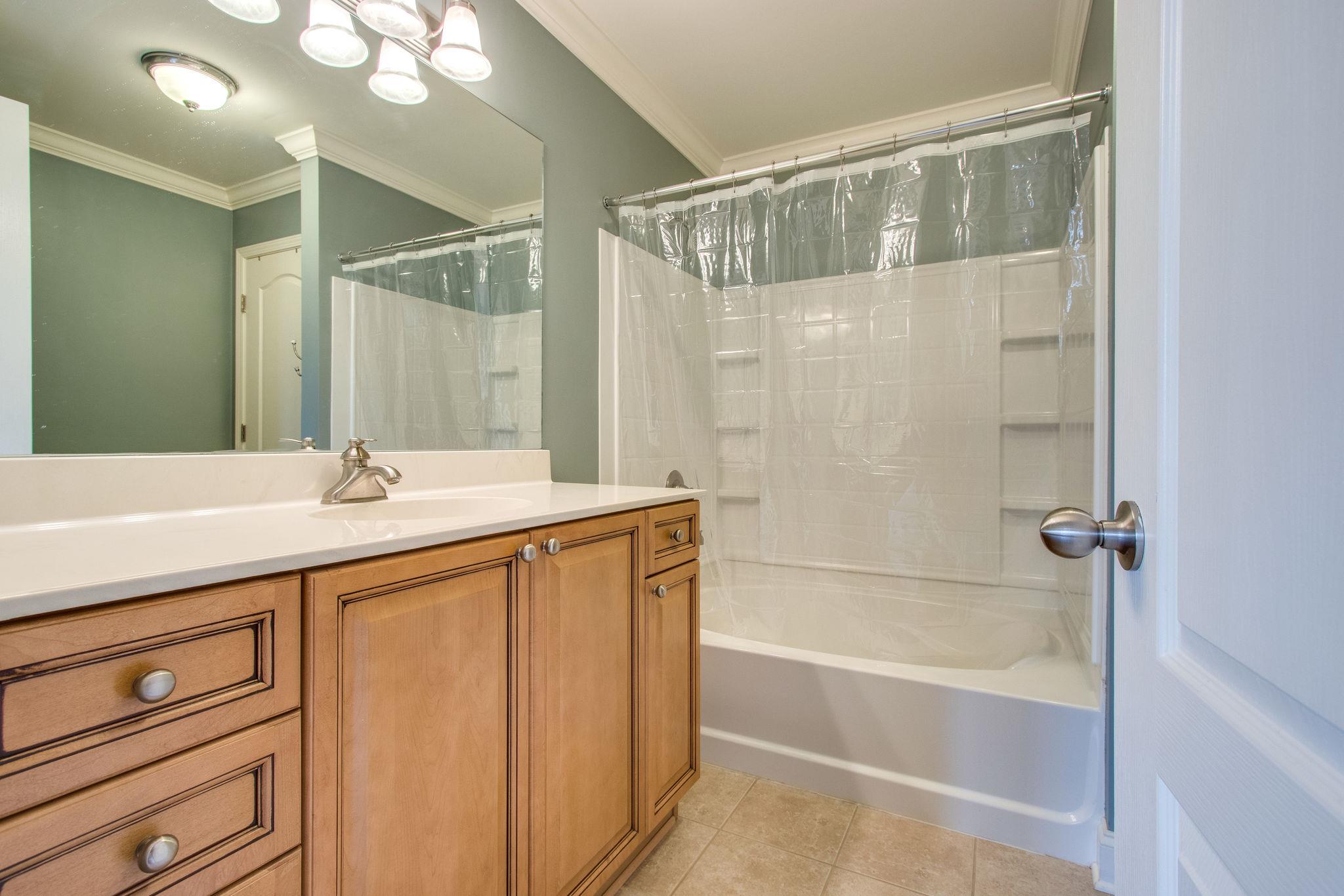 735 Tulip Grove Road, Unit 237 Hermitage, TN 37076 - Photo 20 of 29 a bathroom with a double vanity sink a mirror and a bathtub
