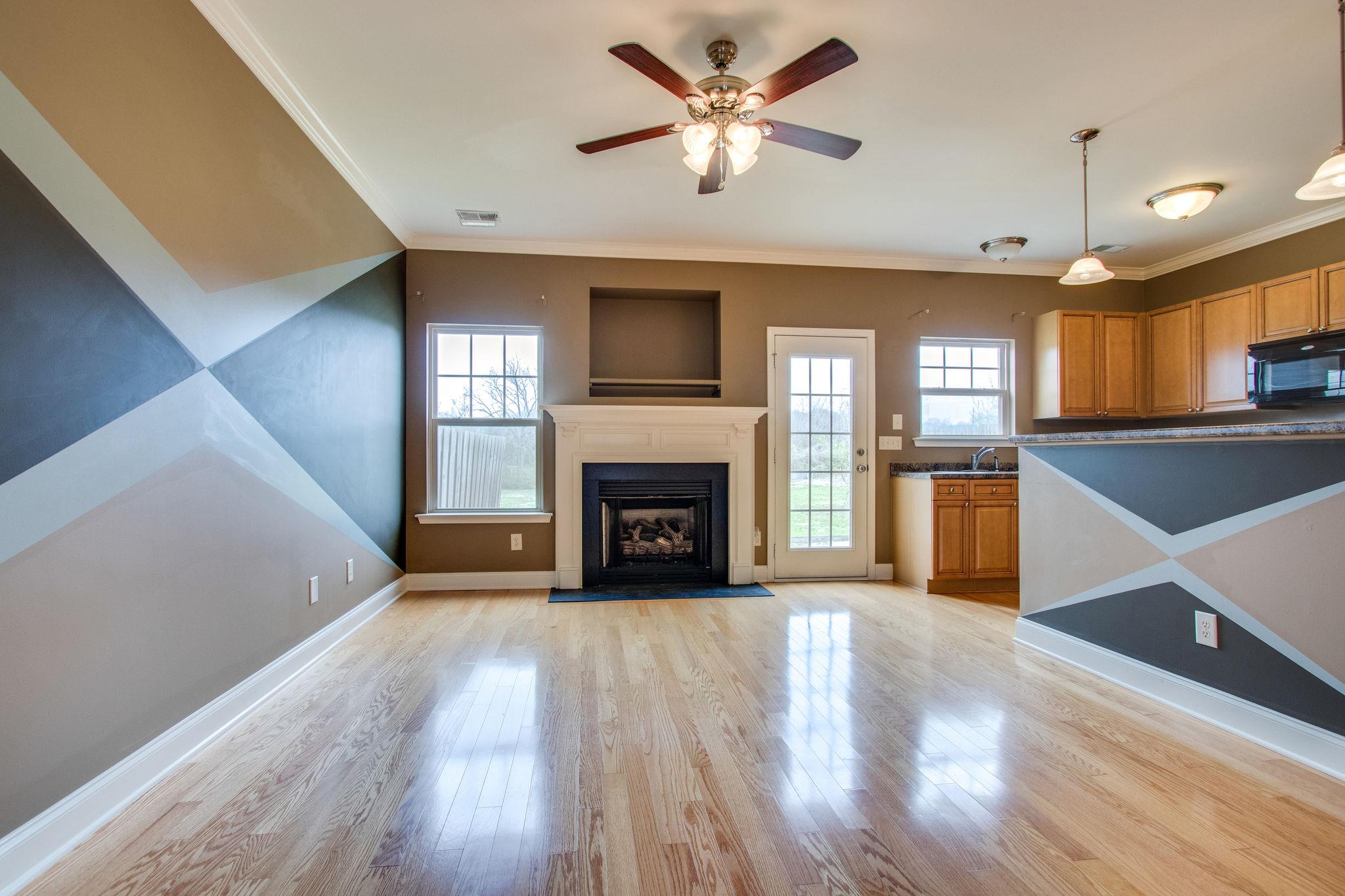 735 Tulip Grove Road, Unit 237 Hermitage, TN 37076 - Photo 7 of 29 a view of a kitchen with a fireplace a ceiling fan and wooden floor