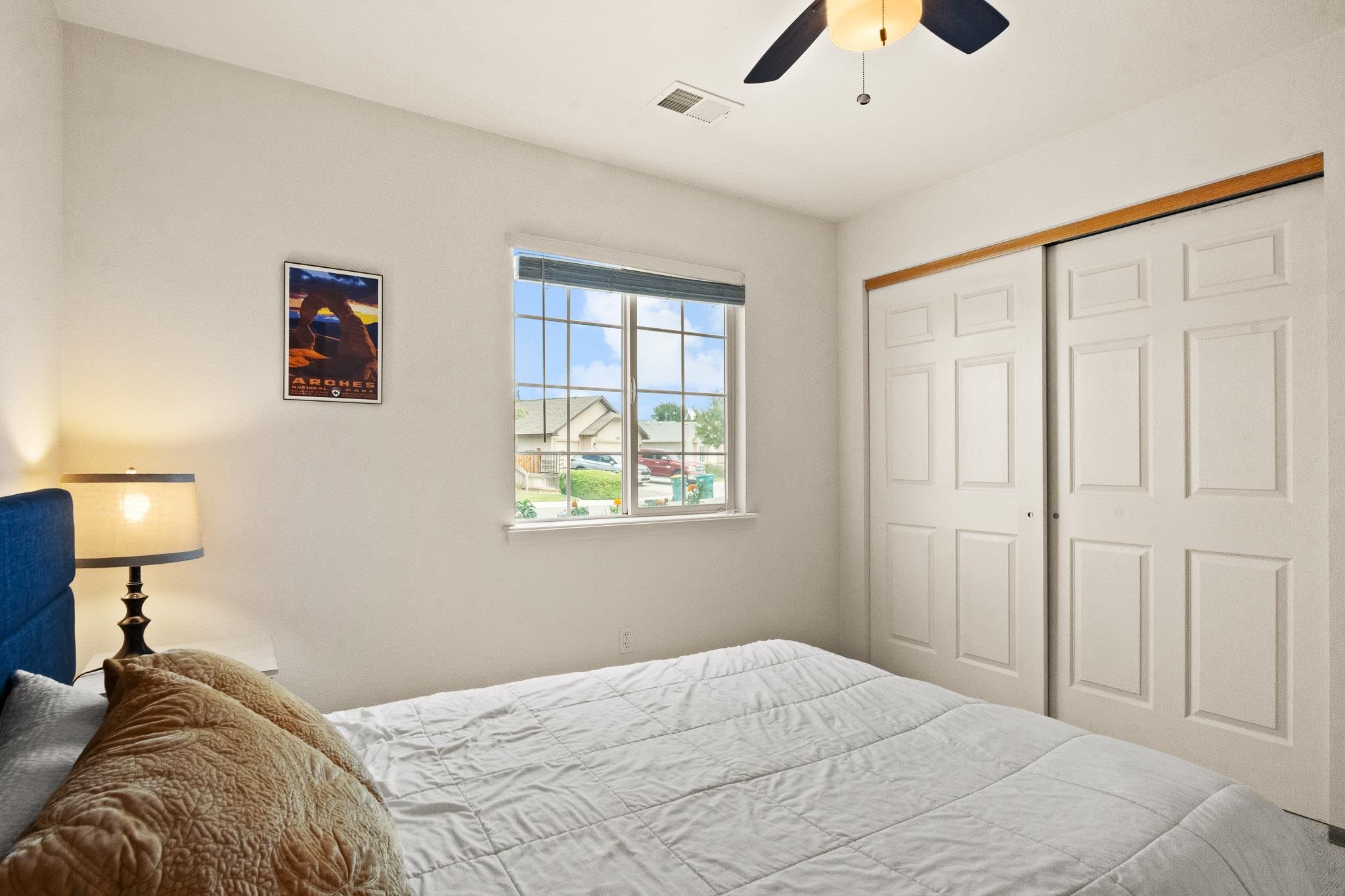 912 Kaley Street Fruita, CO 81521 - Photo 14 of 32 a bedroom with a bed and a lamp on dresser