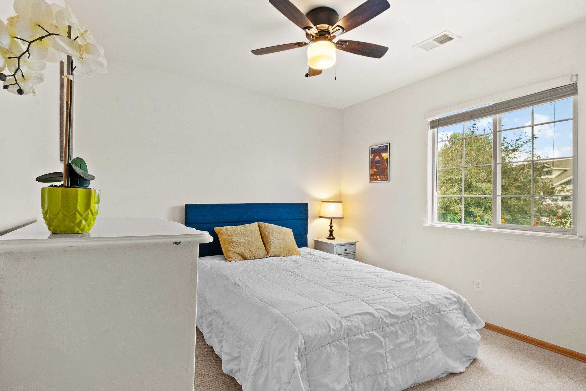 912 Kaley Street Fruita, CO 81521 - Photo 15 of 32 a bedroom with a bed and a chandelier