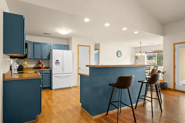 a kitchen with a refrigerator a stove top oven a sink dishwasher and wooden cabinets