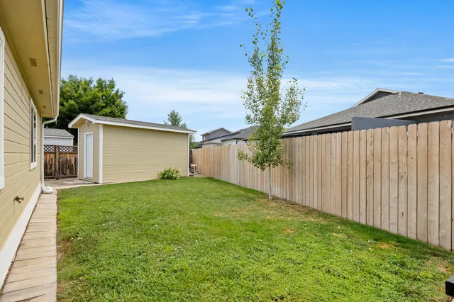 a view of a house with a small yard and wooden fence