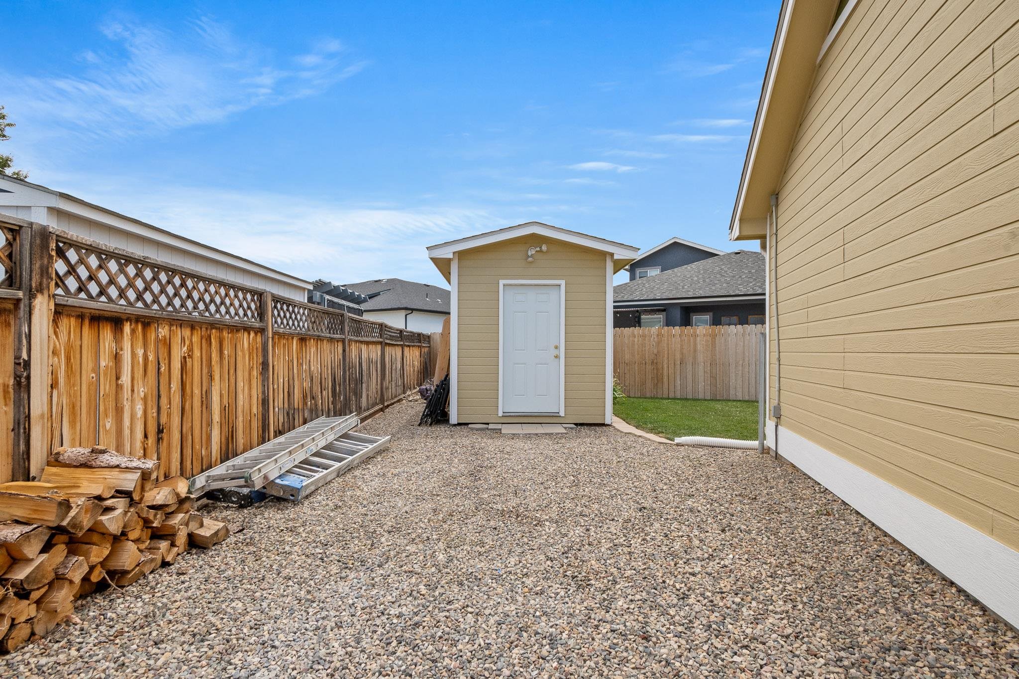 912 Kaley Street Fruita, CO 81521 - Photo 23 of 32 a view of a house with a small yard and wooden fence