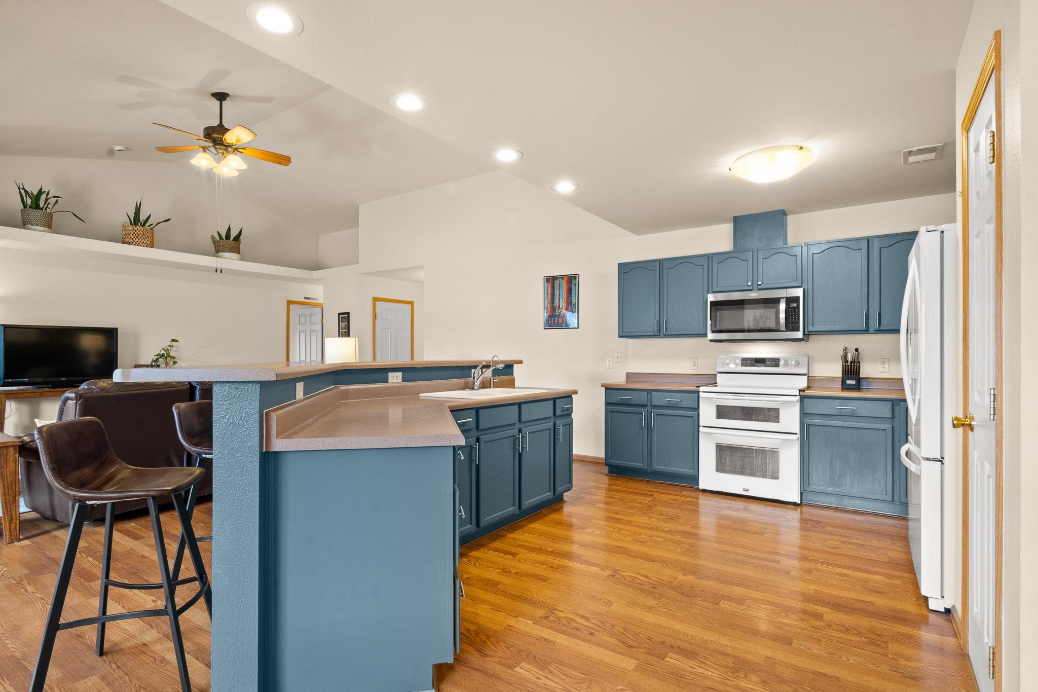 912 Kaley Street Fruita, CO 81521 - Photo 10 of 32 a kitchen with kitchen island granite countertop wooden floors and stainless steel appliances