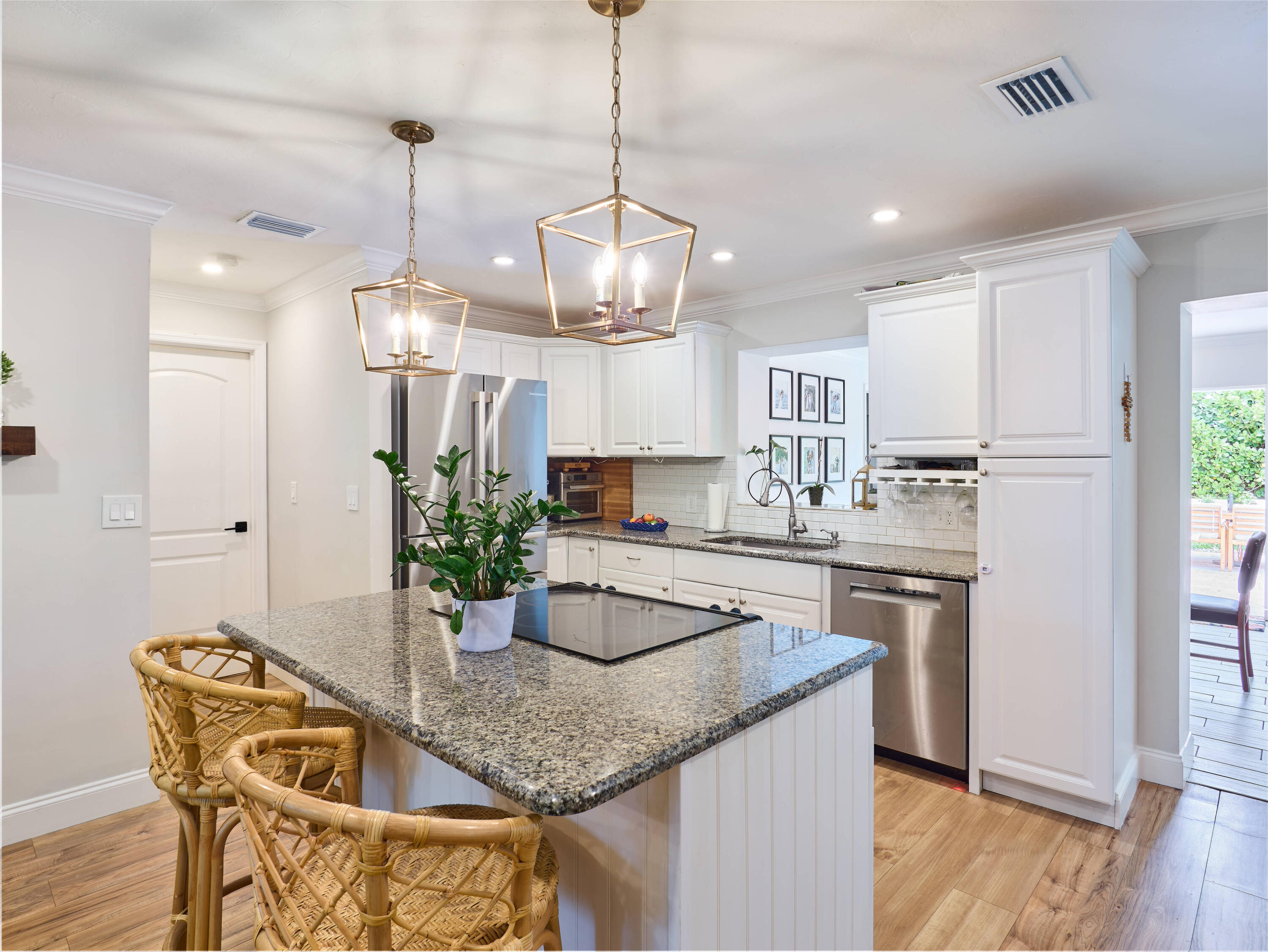 359 Church Road Tequesta, FL 33469 - Photo 7 of 30 a kitchen with stainless steel appliances granite countertop a dining table chairs and white cabinets