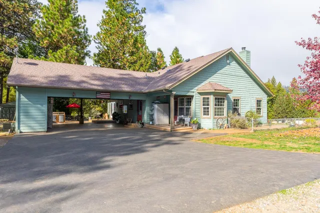 a view of a patio with table and chairs potted plants and a large window