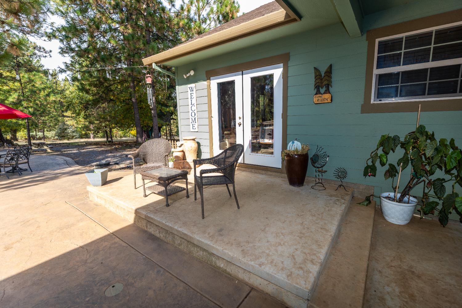 10070 Swiss Ranch Road Mountain Ranch, CA 95246 - Photo 5 of 64 a view of a patio with table and chairs potted plants and a large window