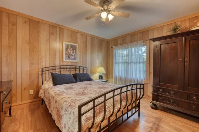 a bed sitting in a spacious bedroom next to a window
