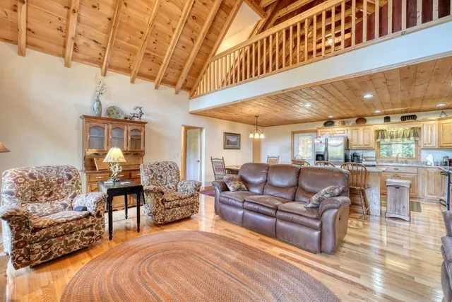 a living room with furniture a fireplace a flat screen tv and a large window