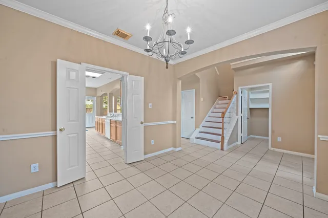a view of a hallway with chandelier and entryway