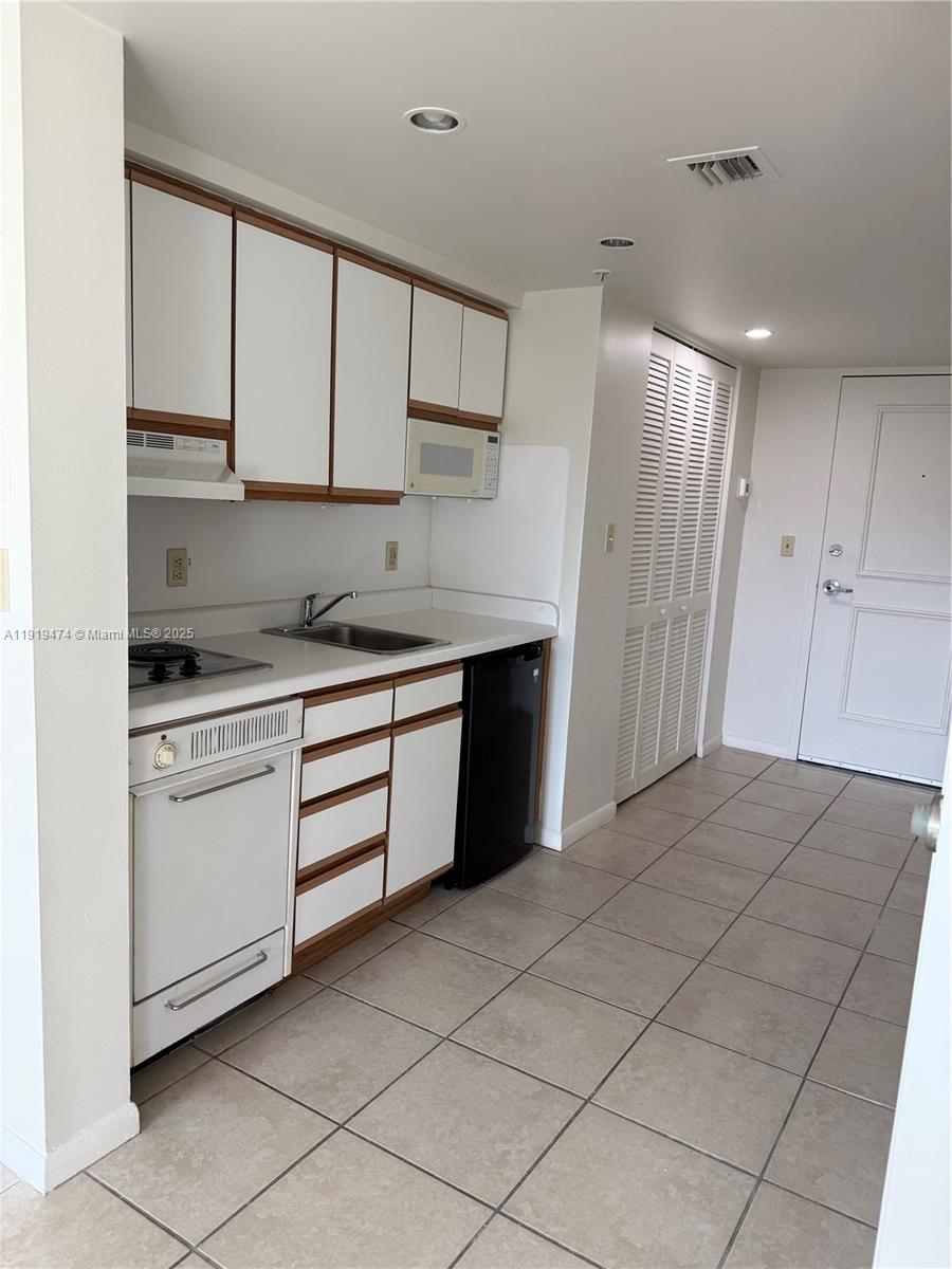 5717 Southwest 72nd Street, Unit 5717 South Miami, FL 33143 - Photo 2 of 6 a kitchen with a cabinets and appliances