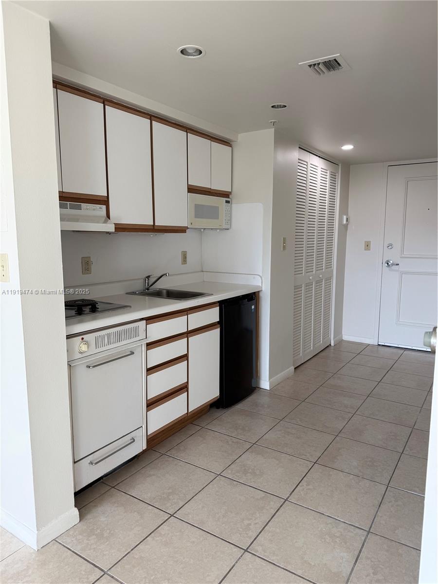 5717 Southwest 72nd Street, Unit 5717 South Miami, FL 33143 - Photo 3 of 6 a kitchen with a cabinets and appliances