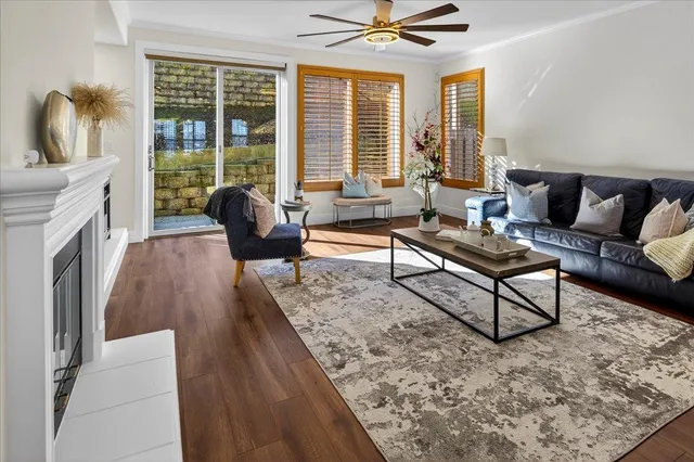 a living room with furniture a fireplace and a dining table with wooden floor