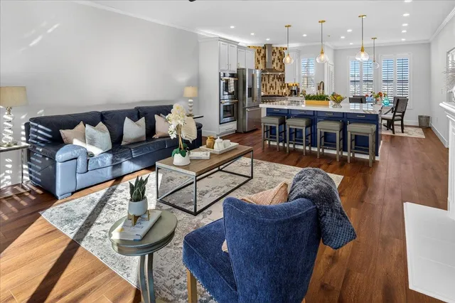 a kitchen with granite countertop a table chairs stainless steel appliances and wooden floor