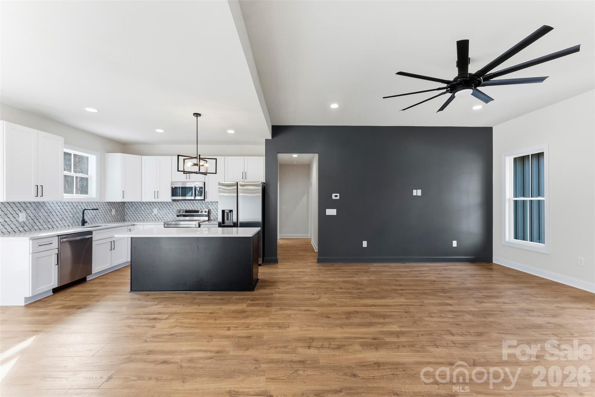 1724 Barnhardt Road China Grove, NC 28023 - Photo 10 of 46 a large kitchen with kitchen island a stove a sink dishwasher a refrigerator and white cabinets with wooden floor
