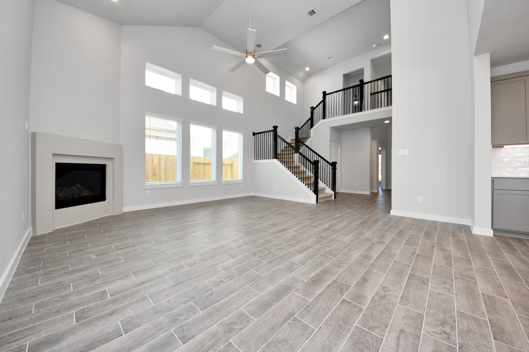 3002 Bury Park Dr Spring Spring, TX 77373 - Photo 11 of 45 Welcome family and guests to your charming living room! With its high ceilings, recessed lighting, ceiling fan, custom paint, beautiful flooring, and large windows that let in abundant natural light, this room is perfect for gatherings.