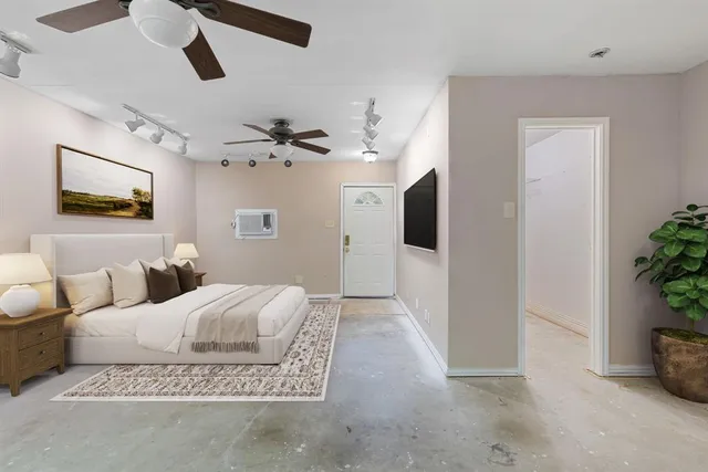 a bedroom with a large bed a chandelier and a potted plant