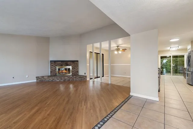 an empty room with wooden floor and fireplace