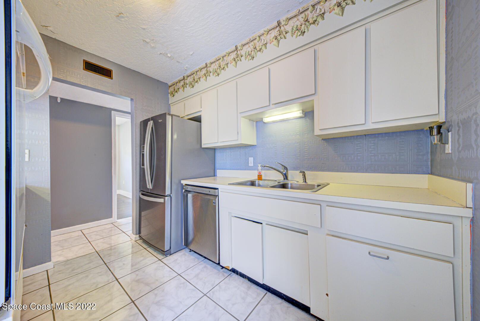 620 Java Road Cocoa Beach, FL 32931 - Photo 11 of 39 a kitchen with stainless steel appliances a refrigerator sink and cabinets