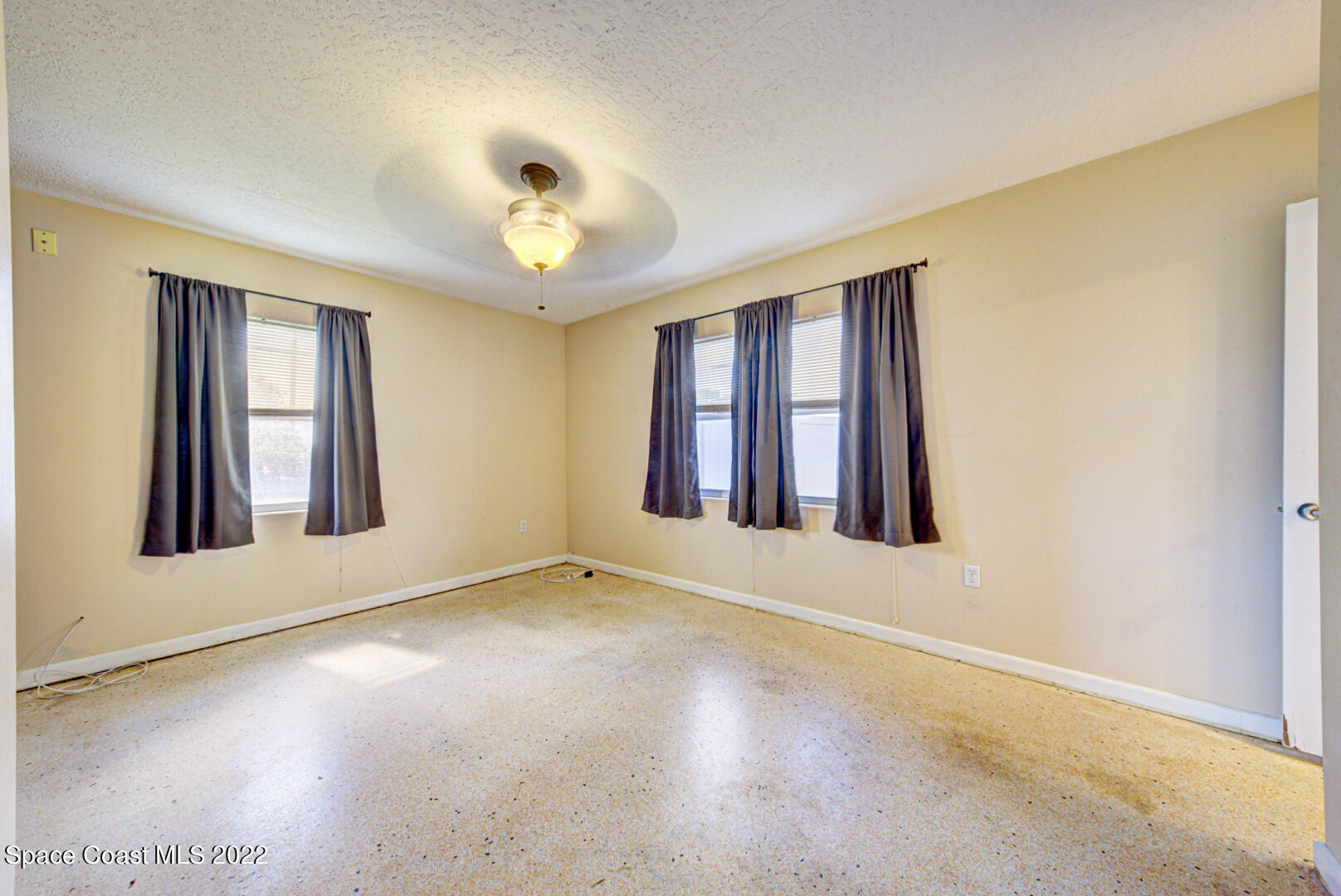620 Java Road Cocoa Beach, FL 32931 - Photo 17 of 39 an empty room with windows and chandelier fan