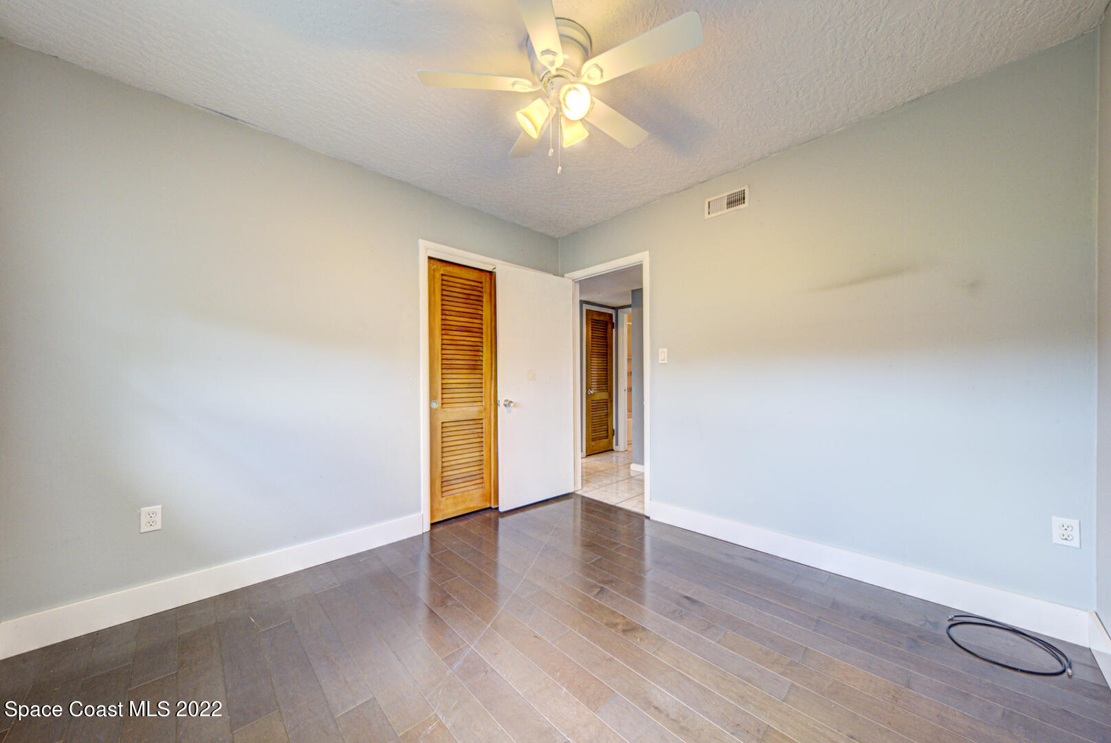 620 Java Road Cocoa Beach, FL 32931 - Photo 22 of 39 a view of an empty room with window and wooden floor