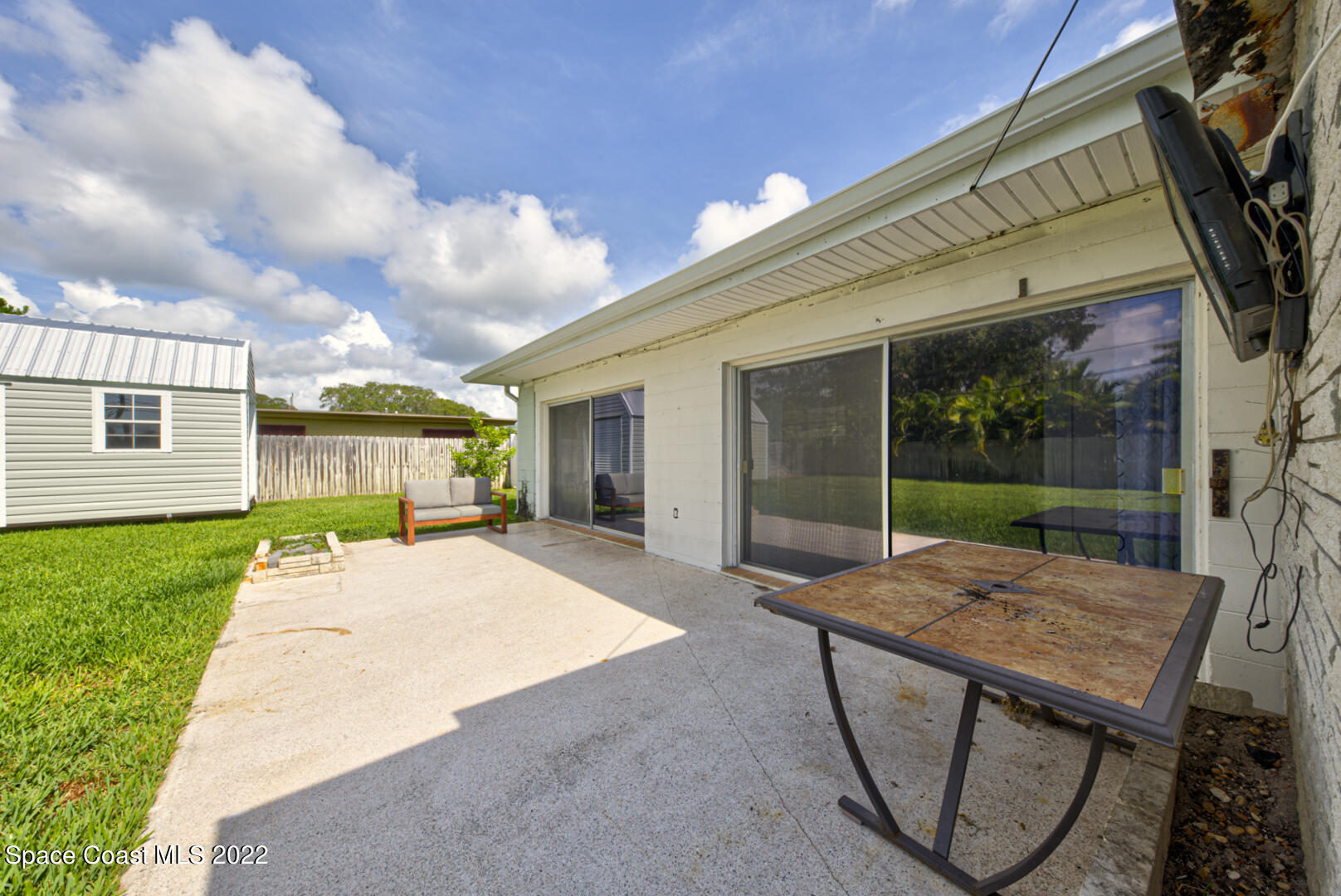 620 Java Road Cocoa Beach, FL 32931 - Photo 31 of 39 a patio with a table and chairs and potted plants