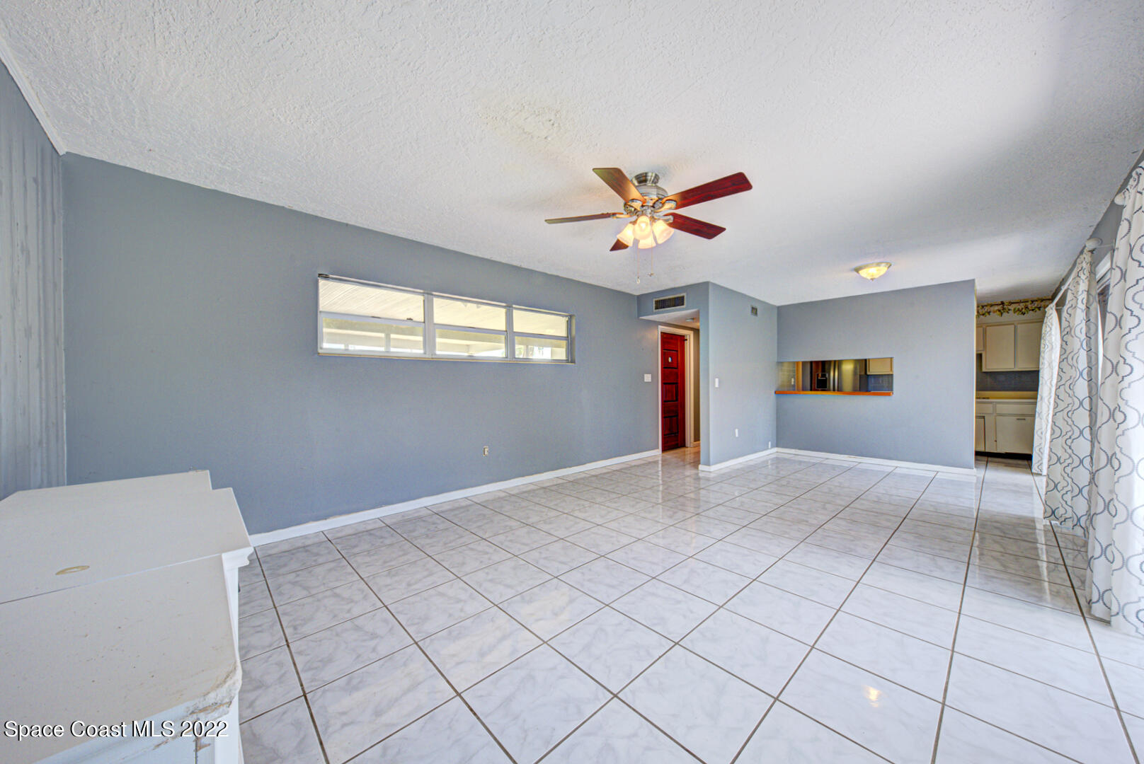 620 Java Road Cocoa Beach, FL 32931 - Photo 9 of 39 a view of an empty room with window and chandelier fan