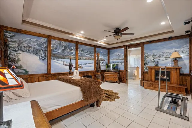 a bedroom with a large bed a flat screen tv and couches next to a large window