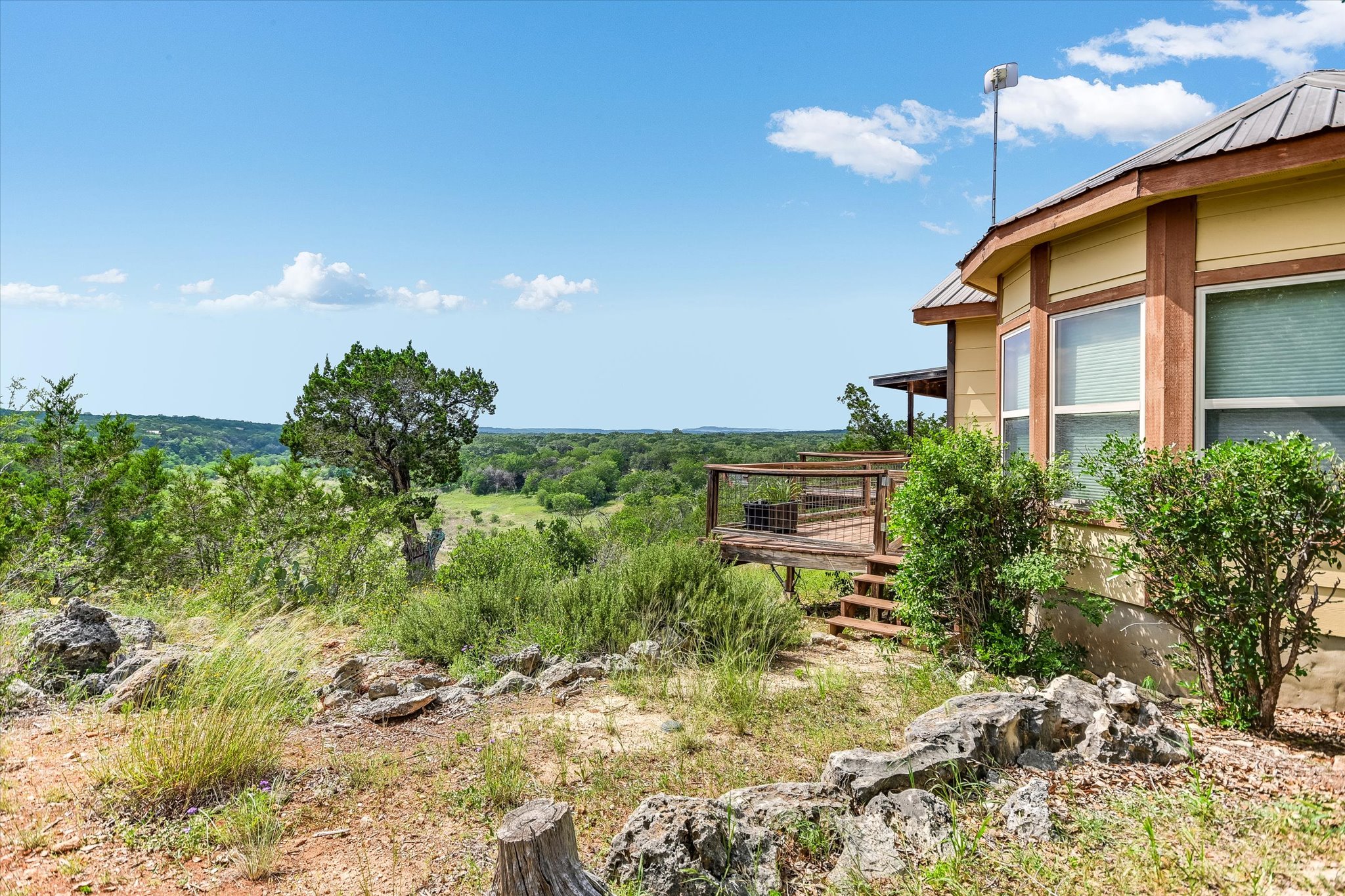 700 Cliffside Road Wimberley, TX 78676 - Photo 18 of 22 Exterior property featuring a rounded architectural design with a metal roof and light-colored siding