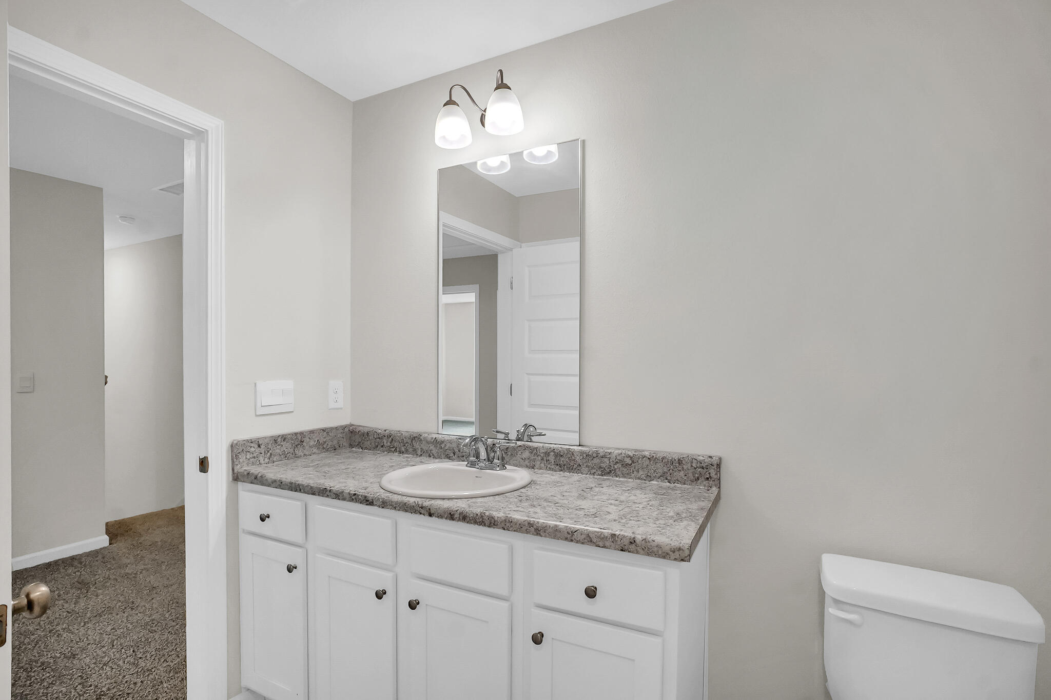 34 Sandywoods Court Freeport, FL 32439 - Photo 36 of 41 a bathroom with a granite countertop sink a toilet and a mirror