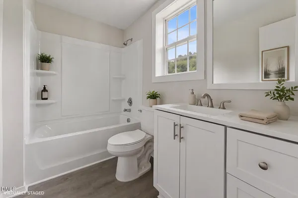 a bathroom with a sink toilet a mirror and shower