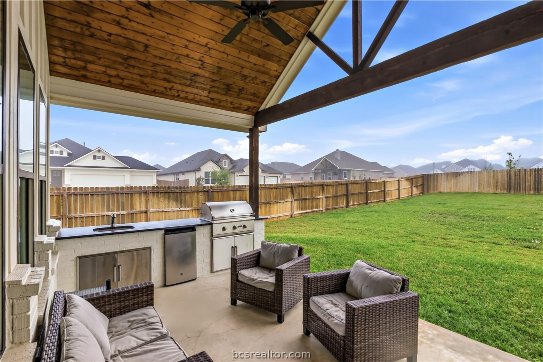 3512 Castine Court Bryan, TX 77808 - Photo 4 of 45 Lovely Covered patio with kitchen including grill, mini fridge, sink, tv & mount